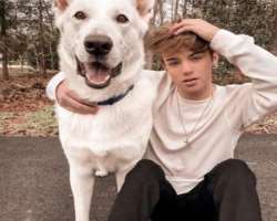 The star is accompanied by a big dog in his home.